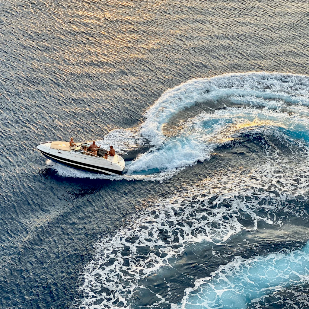 Bateau à moteur fendant la mer turquoise