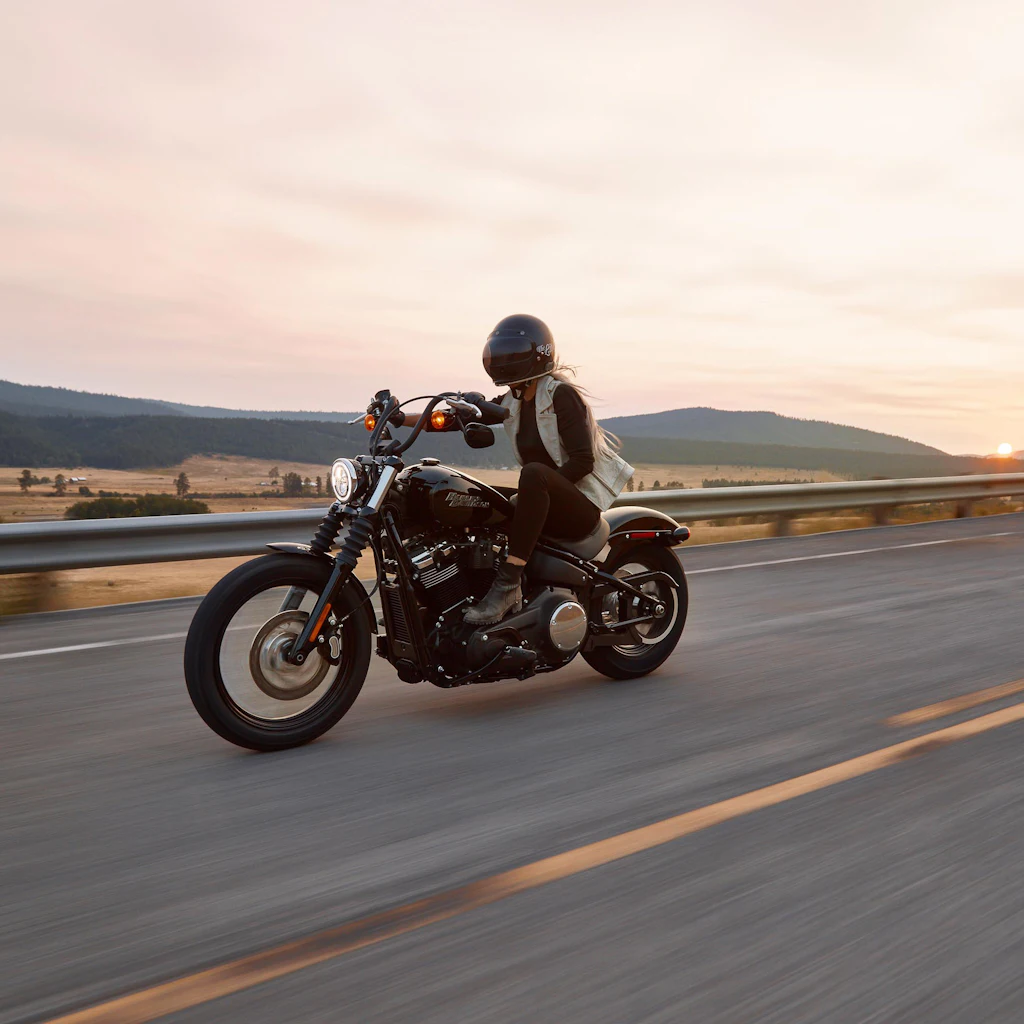 Motard penché dans un virage au coucher du soleil