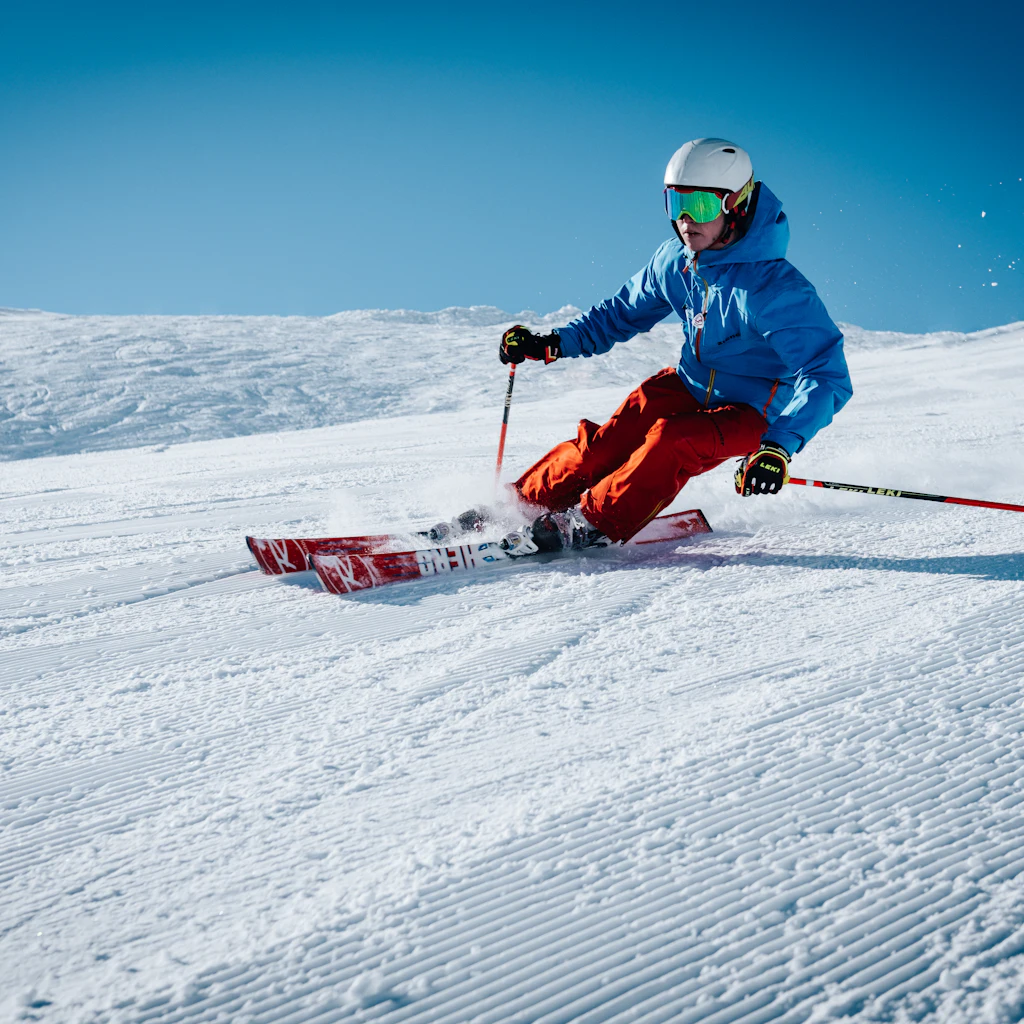 Skieur taillant un virage dans la poudreuse alpine